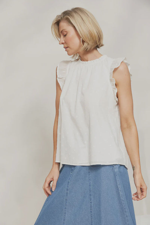 The Zephyr Tank brings a fresh addition to your summer wardrobe. Boasting a relaxed fit, hip-length cut and an airy cotton blend, this tank is perfect for keeping cool on those hot summer days while still looking chic. This tank exudes effortlessness with a charming round neck, short frilled sleeves, and delicate Swiss dot detailing. Style it for lunch with the girls with a maxi skirt, sandals and understated accessories.