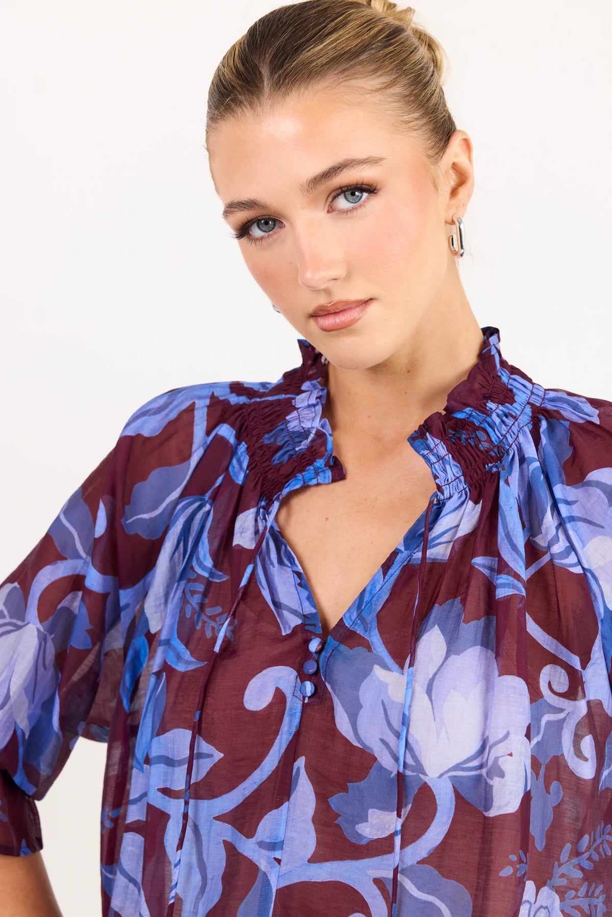 - V-neckline
- Shirred neckline
- Short puff sleeves
- Shirred cuffs with frill detailing
- Delicate front button detail
- Adjustable neckline ties
- Relaxed oversized fit
- Delicate garment care
- Fabric Composition - 80% Viscose 20% Nylon