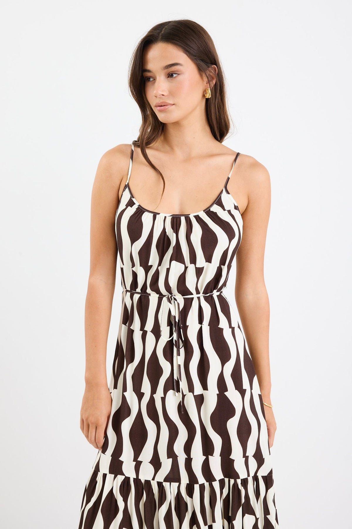 Bold chocolate and cream geometric print

Strappy sleeves for a relaxed summer feel

Tiered design for movement and flow

Lightweight, breathable fabrication

Easy, throw-on silhouette for everyday wear

Fabric Composition
100% Viscose