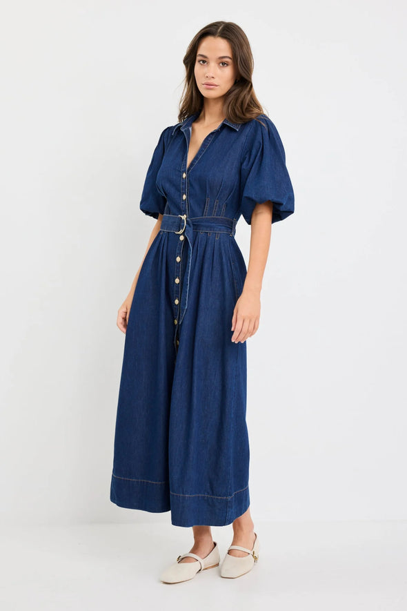 Dark indigo denim dress with a structured silhouette

Button-down front and panel seam detailing

D-ring belt for an adjustable, flattering fit

Soft puff sleeves with gentle volume

80% Cotton, 20% Polyester – durable yet comfortable

Style it casual or elevated for endless versatility