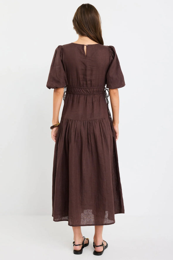 100% linen for breathable, natural comfort

Puff sleeves with soft volume for a feminine touch

Adjustable waist ties for a custom fit

Tiered skirt adds movement and flow

Midi length for timeless, versatile styling

Chocolate brown hue for an elegant, earthy look

Perfect for both casual wear and dressier occasions
