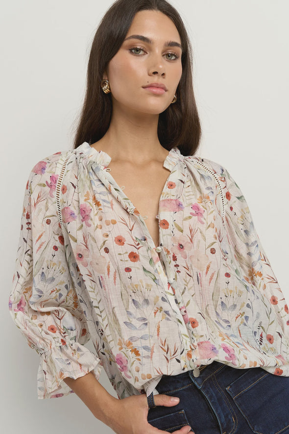 Add a playful touch to your wardrobe with the Encounter cream top. Delicate lace inserts at the shoulders and frilly details on the collar and sleeve cuffs bring a sweet, feminine vibe. The flattering V-neckline and button front make it easy to wear, while short sleeves keep you cool and breezy all summer long. Perfect for brightening up any outfit with a charming twist!