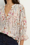 Add a playful touch to your wardrobe with the Encounter cream top. Delicate lace inserts at the shoulders and frilly details on the collar and sleeve cuffs bring a sweet, feminine vibe. The flattering V-neckline and button front make it easy to wear, while short sleeves keep you cool and breezy all summer long. Perfect for brightening up any outfit with a charming twist!