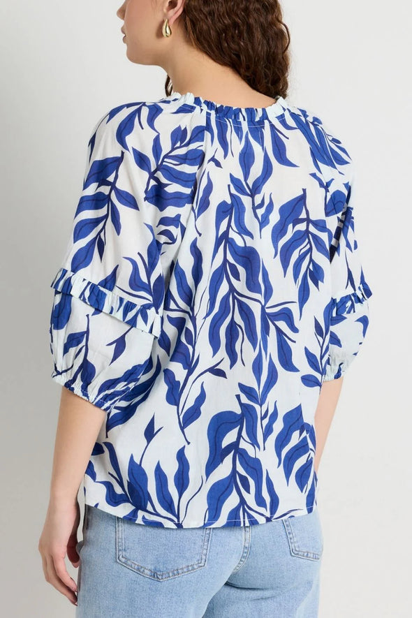 Elevate your style with our Luminary Blue Leaves Top. Featuring a quirky blue leaf print and a playful tie detail at the v neckline, this top adds a touch of fun to your wardrobe. The soft, lightweight cotton material provides comfort for everyday wear. (Fun fact: it also has half sleeves for extra coverage!)