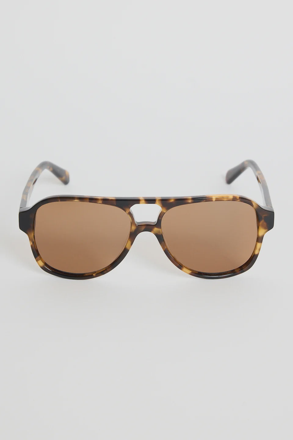 The Cannes Tort Aviator Sunglasses bring a sleek, modern twist to the classic aviator shape. Designed with a bold tortoiseshell frame and softly rounded aviator lenses, they offer that effortless mix of statement and sophistication. Warm brown lenses keep the look cohesive and flattering, making this pair an easy go-to for sunny days, road trips, and everyday wear.

A timeless style with a chic, contemporary edge.

- Modern aviator shape
- Tortoiseshell frame
- Brown tinted lenses
- Angular top bar detail
-