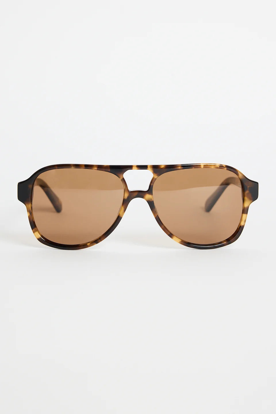 The Cannes Tort Aviator Sunglasses bring a sleek, modern twist to the classic aviator shape. Designed with a bold tortoiseshell frame and softly rounded aviator lenses, they offer that effortless mix of statement and sophistication. Warm brown lenses keep the look cohesive and flattering, making this pair an easy go-to for sunny days, road trips, and everyday wear.

A timeless style with a chic, contemporary edge.

- Modern aviator shape
- Tortoiseshell frame
- Brown tinted lenses
- Angular top bar detail
-