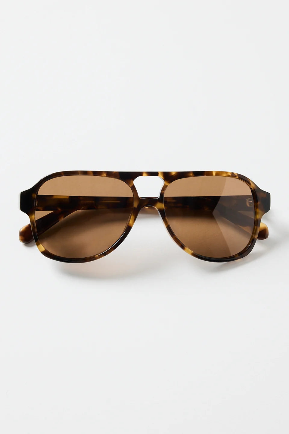 The Cannes Tort Aviator Sunglasses bring a sleek, modern twist to the classic aviator shape. Designed with a bold tortoiseshell frame and softly rounded aviator lenses, they offer that effortless mix of statement and sophistication. Warm brown lenses keep the look cohesive and flattering, making this pair an easy go-to for sunny days, road trips, and everyday wear.

A timeless style with a chic, contemporary edge.

- Modern aviator shape
- Tortoiseshell frame
- Brown tinted lenses
- Angular top bar detail
-