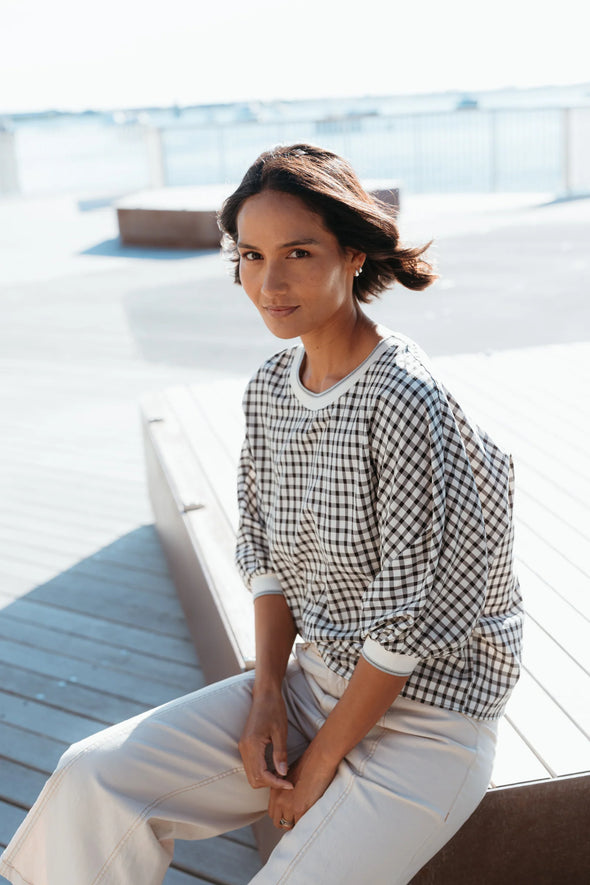 Best-selling easy fit top updated in a check print

Contrast striped rib neck and cuffs for a luxe finish

Playful monochrome design for versatile styling

Crafted from a comfortable 94% Polyester, 6% Spandex blend

A wardrobe must-have for easy, everyday chic