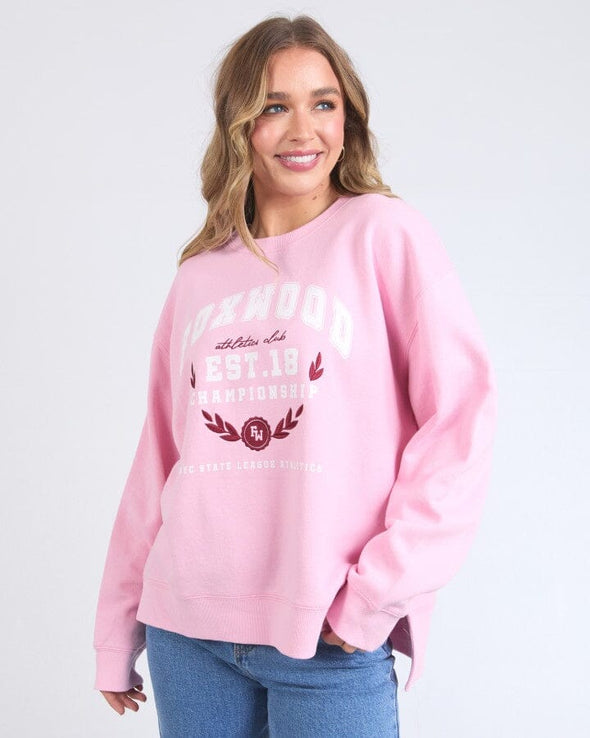Snuggle up in style with Foxwood's Women's Pink Sweatshirt! The eye-catching "Foxwood" logo adds just the right amount of sass to this ultra-cozy essential. Crafted from fabric so soft you'll want to live in it, this pretty-in-pink number transitions effortlessly from Netflix marathons to coffee dates. Warning: Friends may experience extreme outfit envy when you rock this with your go-to leggings or jeans!