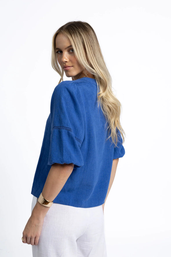 Crafted from a breathable, eco-friendly linen, cotton ramie, and tencel blend

Flattering V-neckline with self-covered button closure

Pintuck detailing on shoulders for subtle texture

Roomy sleeves with trim and elastic cuffs for versatile styling

Relaxed fit pairs easily with jeans, shorts, or linen pants