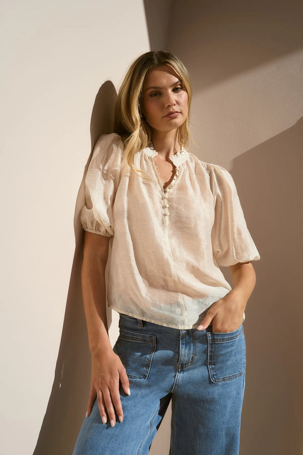 Start your day with a playful twist in the Closure Top. Featuring a high neck with charming frill details and a button front, this top also boasts mid-length balloon sleeves for added fun. Made from a semi-sheer linen blend, it offers breathable comfort that’s perfect for any occasion.