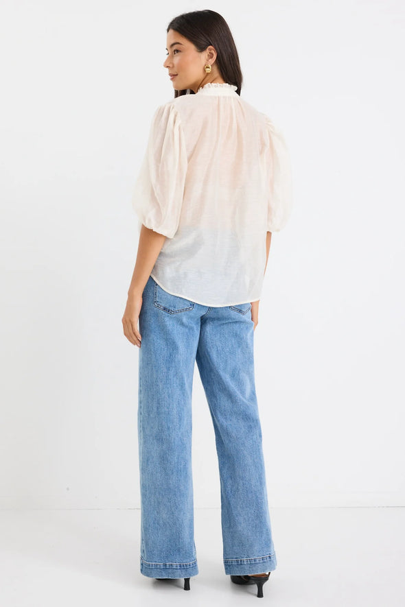 Start your day with a playful twist in the Closure Top. Featuring a high neck with charming frill details and a button front, this top also boasts mid-length balloon sleeves for added fun. Made from a semi-sheer linen blend, it offers breathable comfort that’s perfect for any occasion.