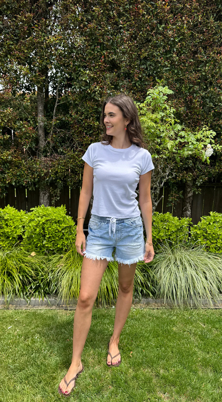 Rigid denim frayed shorts with an elastic waist band and shoe string tie. In the perfect faded light blue.

Can be worn higher or lower on the waist as preferred. Medium length with good coverage.