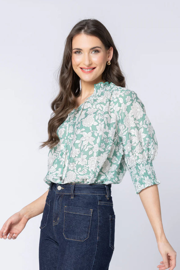 Pretty sage-green base with white bloom print

Relaxed, easy fit

Elbow-length sleeves

Lightweight and breathable

Perfect for pairing with jeans or summer skirts

Composition: 70% Viscose, 30% Nylon