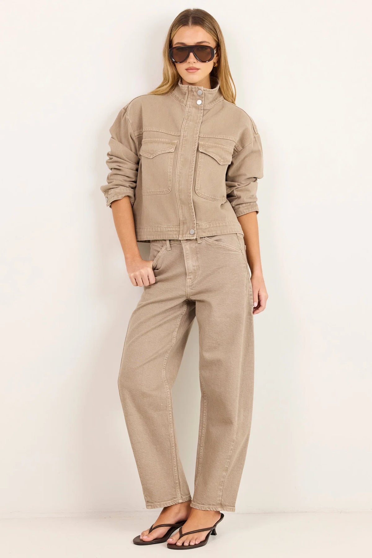 - Funnel neckline
- Front patch pockets
- Button front closure
- Plain taupe denim design
- Structured cotton feel
- Fabric Composition - 100% Cotton