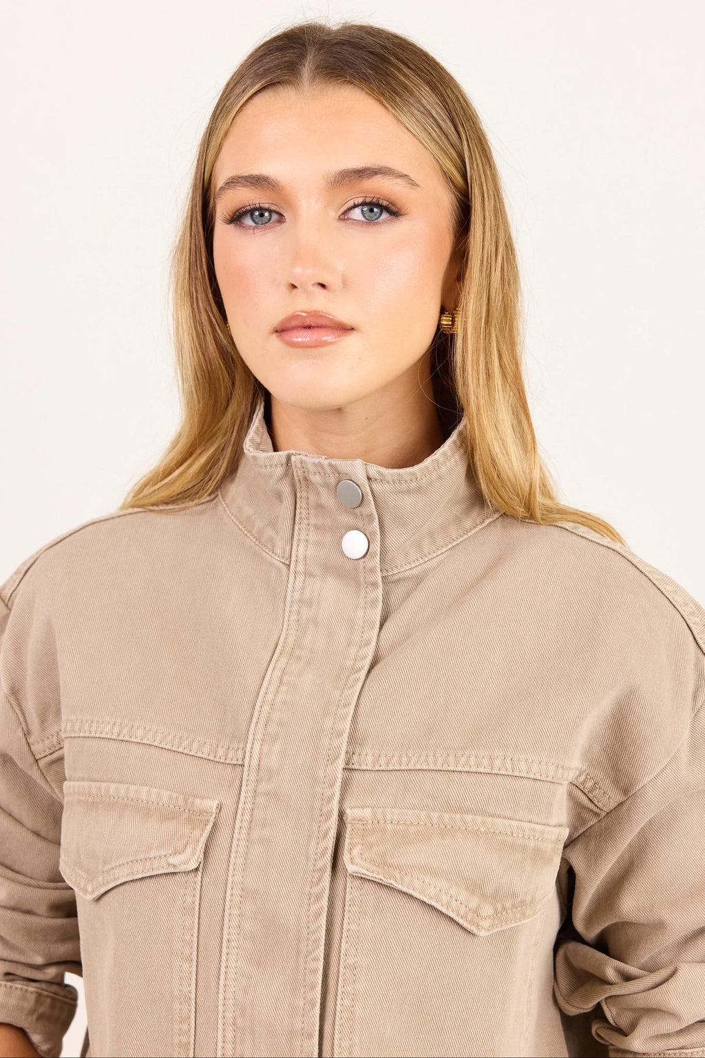 - Funnel neckline
- Front patch pockets
- Button front closure
- Plain taupe denim design
- Structured cotton feel
- Fabric Composition - 100% Cotton