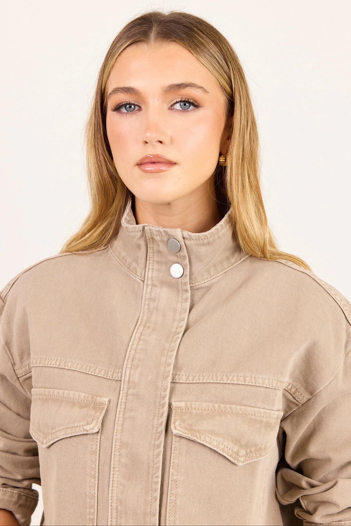 - Funnel neckline
- Front patch pockets
- Button front closure
- Plain taupe denim design
- Structured cotton feel
- Fabric Composition - 100% Cotton
