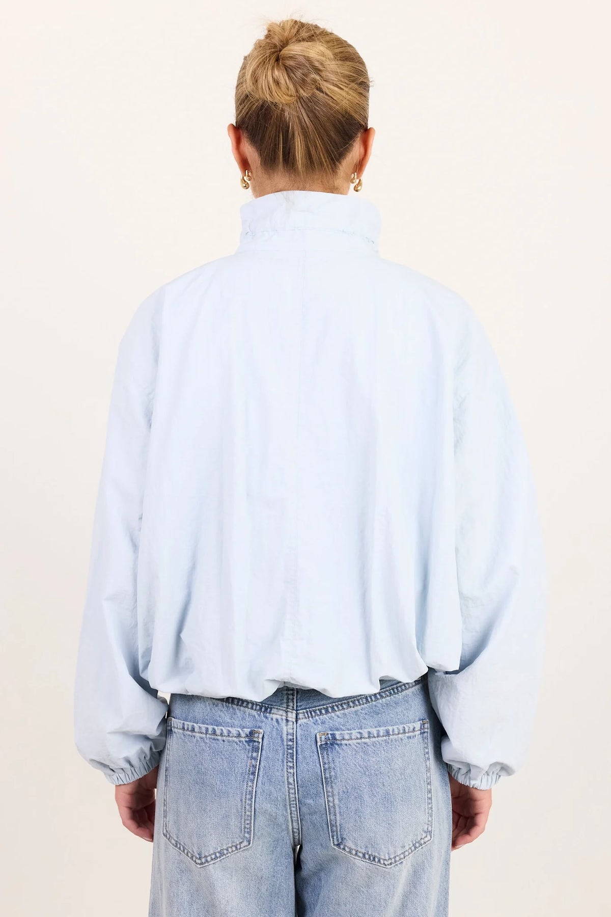 - High funnel neckline
- Long sleeves with elasticated cuffs
- Concealed zip-front fastening
- Adjustable neckline ties
- Relaxed oversized fit
- Elasticated hem
- Side pockets
- Fabric Composition - 100% Nylon