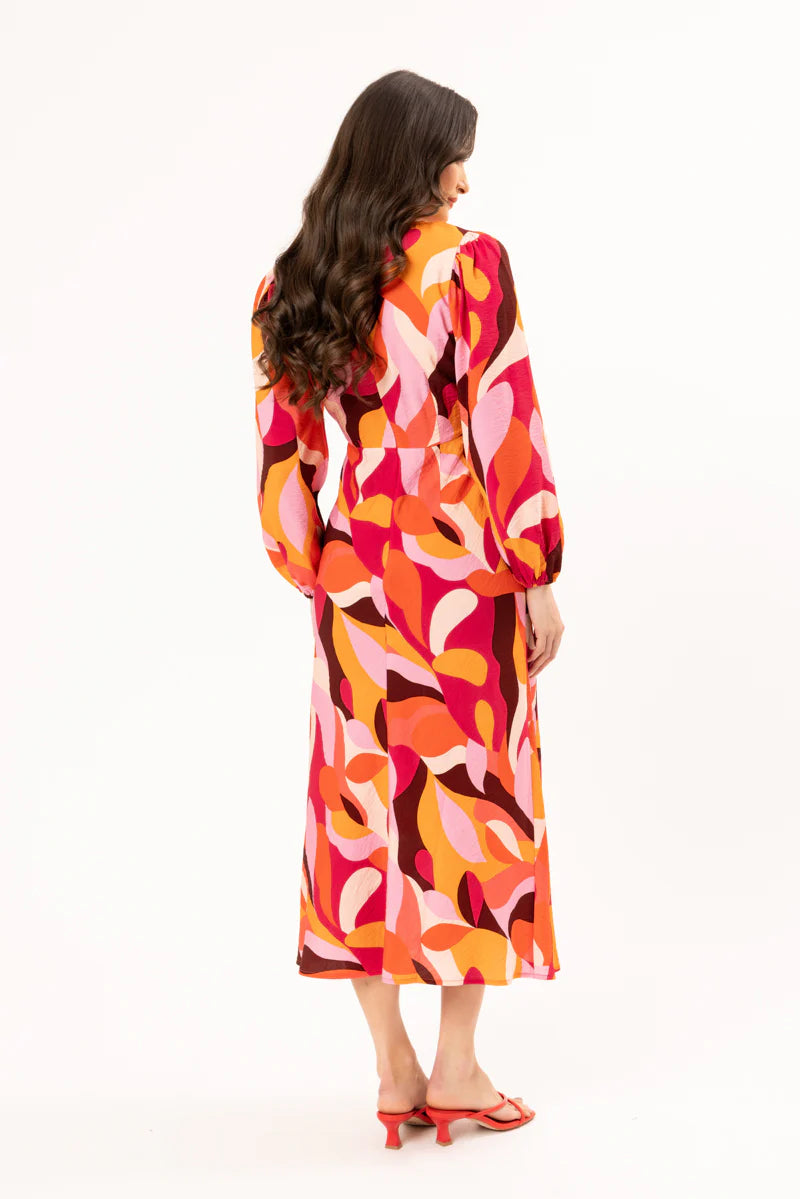 Elevate your wardrobe with our stunning long-sleeved maxi dress, crafted from a fun bright patterned fabric that effortlessly blends style and comfort. Featuring a flattering round neck with a v-neck detail and tie, this dress showcases a shaped empire bust for a feminine silhouette. The elastic cuff detail adds a touch of sophistication, while the convenient back neck zip ensures easy wear.