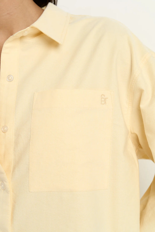 Oversized button-down shirt in pastel lemon

Lightweight cotton with a soft, crisp finish

Classic collared neckline with chest pocket

Wide cuffs and curved hem for a flattering shape

100% Cotton – breathable and easy to style

Wear tucked, tied, layered, or solo for versatile looks