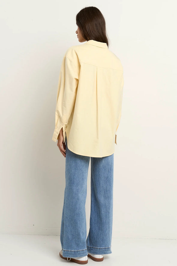 Oversized button-down shirt in pastel lemon

Lightweight cotton with a soft, crisp finish

Classic collared neckline with chest pocket

Wide cuffs and curved hem for a flattering shape

100% Cotton – breathable and easy to style

Wear tucked, tied, layered, or solo for versatile looks