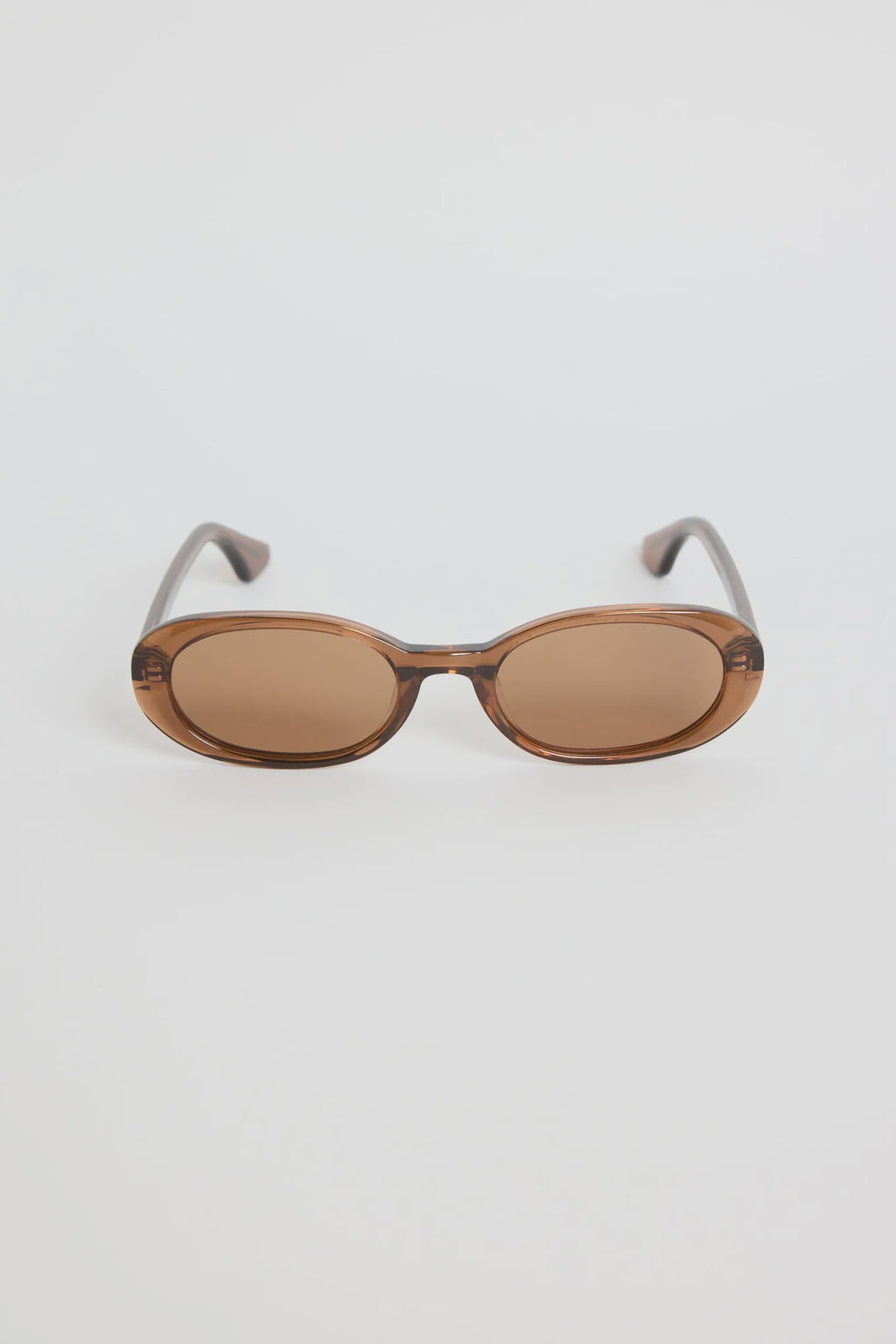 The Sydney Espresso Narrow Oval Sunglasses bring a sleek, retro-inspired touch to your everyday style. Designed in a warm espresso tone, this slim oval frame feels effortlessly cool with its lightweight, glossy finish. The soft brown lenses keep things understated and chic, making this pair an easy match for everything in your wardrobe.

A timeless, wear-anywhere accessory that adds instant polish.

- Recycled Acetate

- UV Protection Category 3