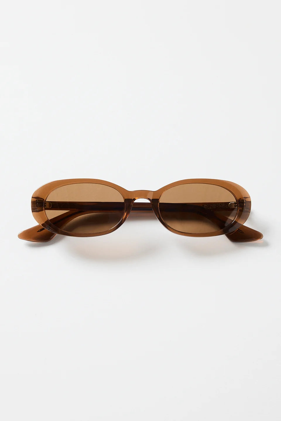 The Sydney Espresso Narrow Oval Sunglasses bring a sleek, retro-inspired touch to your everyday style. Designed in a warm espresso tone, this slim oval frame feels effortlessly cool with its lightweight, glossy finish. The soft brown lenses keep things understated and chic, making this pair an easy match for everything in your wardrobe.

A timeless, wear-anywhere accessory that adds instant polish.

- Recycled Acetate

- UV Protection Category 3