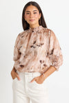 Add a versatile staple to your wardrobe with the Influential Chocolate Floral Shirred Neck Top. Perfect for transitioning from the office to dinner, this top features a high shirred neckline and mid-length balloon sleeves. Pair it with high waisted jeans for a casual look or dress it up with a slip skirt.