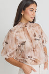 Add a versatile staple to your wardrobe with the Influential Chocolate Floral Shirred Neck Top. Perfect for transitioning from the office to dinner, this top features a high shirred neckline and mid-length balloon sleeves. Pair it with high waisted jeans for a casual look or dress it up with a slip skirt.