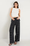 The Clever Black Lines Drawcord Wide Leg Pants offer a relaxed yet refined look with their subtle line print and wide-leg silhouette. Featuring a high-rise fit and adjustable drawcord waist, these trousers provide a flattering and customizable shape. Crafted from a lightweight fabric blend, they ensure breathable comfort from daytime meetings to evening outings.