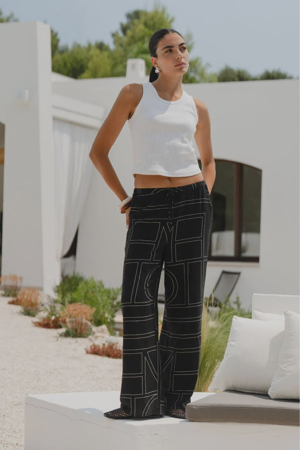 The Clever Black Lines Drawcord Wide Leg Pants offer a relaxed yet refined look with their subtle line print and wide-leg silhouette. Featuring a high-rise fit and adjustable drawcord waist, these trousers provide a flattering and customizable shape. Crafted from a lightweight fabric blend, they ensure breathable comfort from daytime meetings to evening outings.
