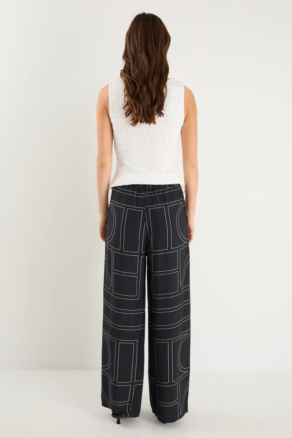 The Clever Black Lines Drawcord Wide Leg Pants offer a relaxed yet refined look with their subtle line print and wide-leg silhouette. Featuring a high-rise fit and adjustable drawcord waist, these trousers provide a flattering and customizable shape. Crafted from a lightweight fabric blend, they ensure breathable comfort from daytime meetings to evening outings.