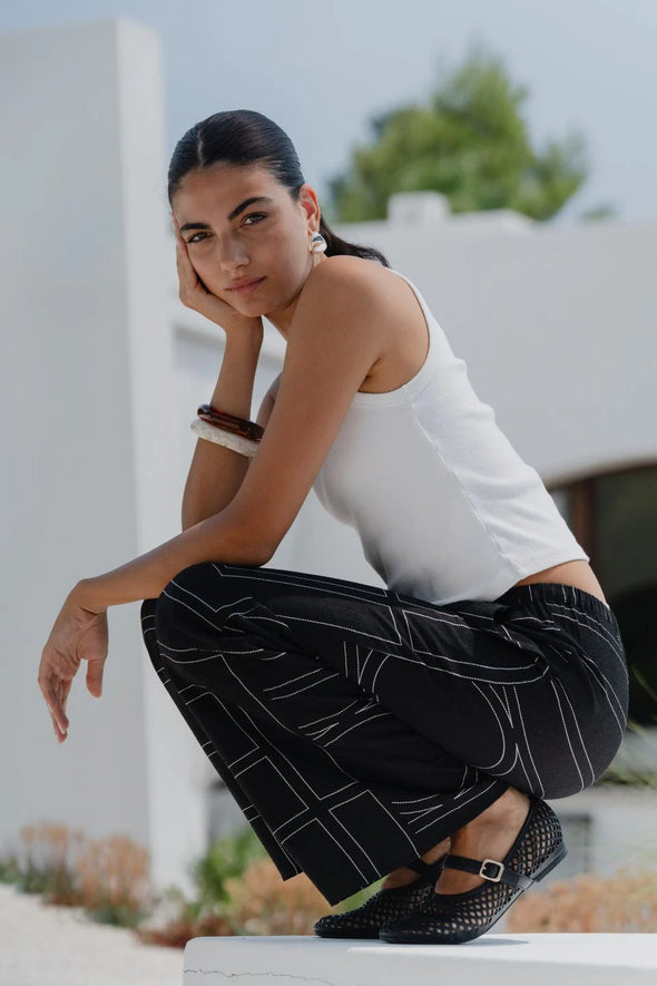 The Clever Black Lines Drawcord Wide Leg Pants offer a relaxed yet refined look with their subtle line print and wide-leg silhouette. Featuring a high-rise fit and adjustable drawcord waist, these trousers provide a flattering and customizable shape. Crafted from a lightweight fabric blend, they ensure breathable comfort from daytime meetings to evening outings.