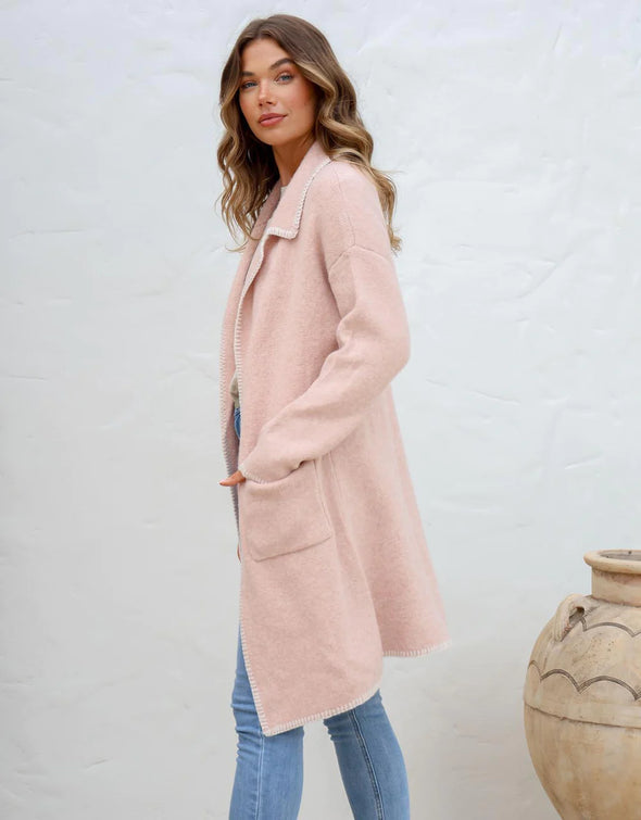 Step out in style with the Blanket Stitch Coatigan, where comfort meets the elegance of a coat with the ease of a cardigan. This chic layering piece, with its soft natural hue and striking black blanket stitch detailing, offers a timeless design that exudes casual elegance. The coatigan's open front, deep patch pockets, and a gently structured collar make it as practical as it is stylish, perfect for transitional weather.