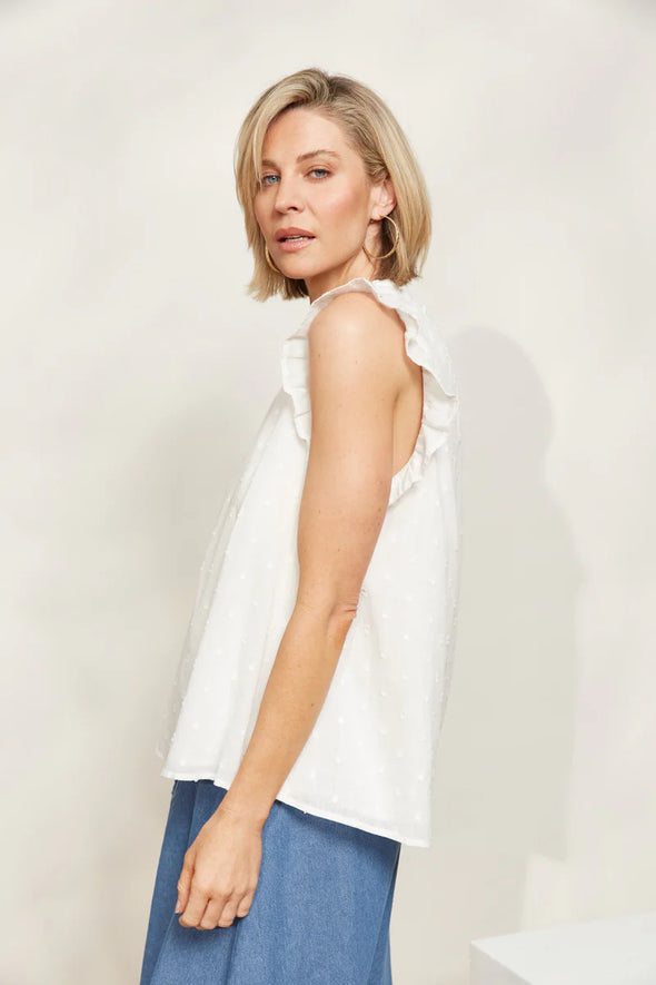 The Zephyr Tank brings a fresh addition to your summer wardrobe. Boasting a relaxed fit, hip-length cut and an airy cotton blend, this tank is perfect for keeping cool on those hot summer days while still looking chic. This tank exudes effortlessness with a charming round neck, short frilled sleeves, and delicate Swiss dot detailing. Style it for lunch with the girls with a maxi skirt, sandals and understated accessories.