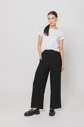 Meet your new go-to: the Billie The Label Essential Wide Leg Pants in classic black. With a sleek flat front waist and comfy elastic back, they fit like a dream. Two handy pockets add practicality to the style, making them perfect for everyday adventures. Crafted from a soft blend of 65% viscose and 35% nylon, these pants offer both comfort and flow with every step.&nbsp;
