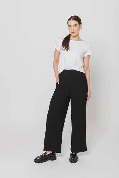Meet your new go-to: the Billie The Label Essential Wide Leg Pants in classic black. With a sleek flat front waist and comfy elastic back, they fit like a dream. Two handy pockets add practicality to the style, making them perfect for everyday adventures. Crafted from a soft blend of 65% viscose and 35% nylon, these pants offer both comfort and flow with every step.&nbsp;