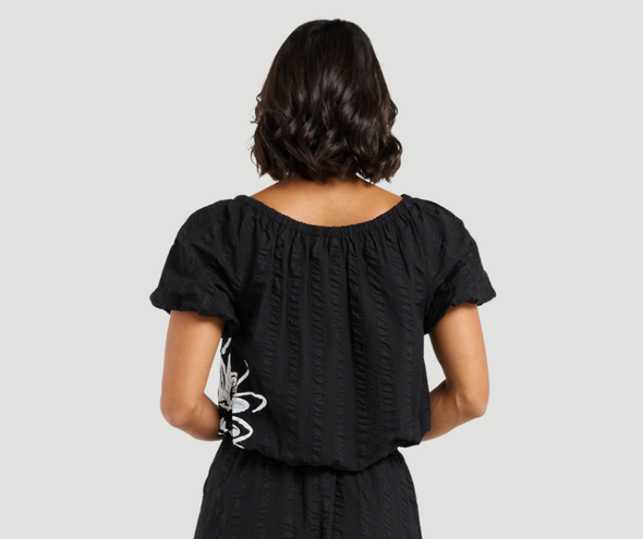 Add a playful twist to your summer wardrobe with this cropped cotton top, featuring short sleeves and fun balloon details at the hem and cuffs for a whimsical shape. The delicate daisy print on the front brings a fresh, floral pop, perfect for warm days. Pair it with the matching Daisy skirt for a charming, coordinated look that’s full of playful summer vibes.