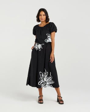 Add a playful touch to your wardrobe with this cropped top, featuring short sleeves and voluminous balloon details at the hem and cuffs for a fun, whimsical shape. The delicate daisy print on the front brings a fresh floral accent to this charming piece. Made from soft 100% rayon, it’s perfect for warm-weather days. Pair it with the matching Daisy skirt for a complete summer-ready look full of cheerful style.