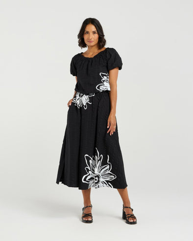 Add a playful touch to your wardrobe with this cropped top, featuring short sleeves and voluminous balloon details at the hem and cuffs for a fun, whimsical shape. The delicate daisy print on the front brings a fresh floral accent to this charming piece. Made from soft 100% rayon, it’s perfect for warm-weather days. Pair it with the matching Daisy skirt for a complete summer-ready look full of cheerful style.