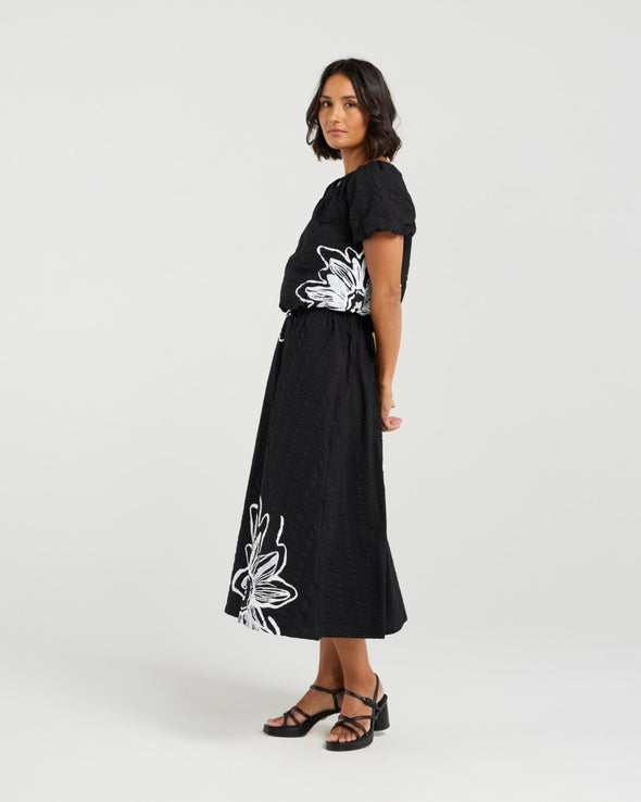 Add a playful touch to your wardrobe with this cropped top, featuring short sleeves and voluminous balloon details at the hem and cuffs for a fun, whimsical shape. The delicate daisy print on the front brings a fresh floral accent to this charming piece. Made from soft 100% rayon, it’s perfect for warm-weather days. Pair it with the matching Daisy skirt for a complete summer-ready look full of cheerful style.