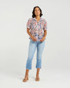 This short-sleeved shirt brings a playful touch with its softly puffed sleeves and delicate smocking that hugs the body. The gathered waist flares out into a subtle peplum, adding a flirty flair that flatters your silhouette. With refined tailoring and just the right amount of volume, it balances comfort and charm perfectly—ready to dress up your day or add fun to your casual look.
