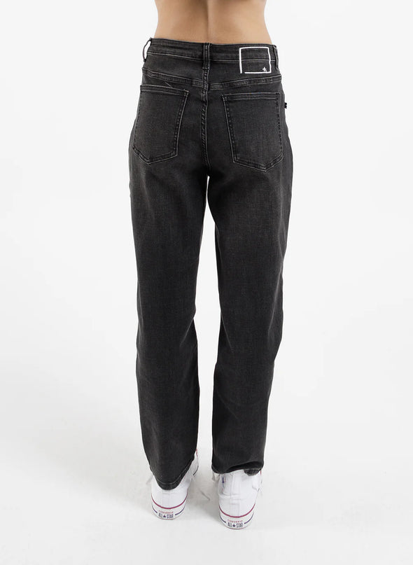 Introducing our Take It Easy Jean. Made with high-quality denim and a relaxed fit, these Black jeans are perfect for everyday wear. The versatile design and ample room for movement make them a must-have addition to your wardrobe. So comfy, you'll never want to take them off! With iconic printed logos on the legs and a fun worded print on the back.