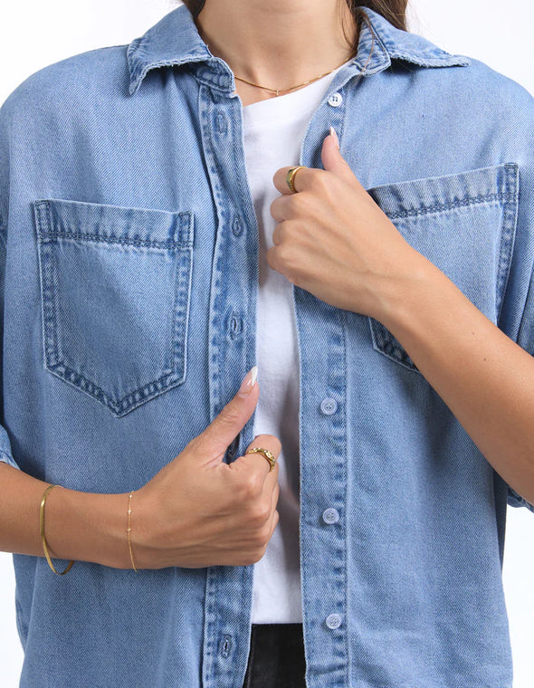 Get ready to elevate your denim game with the Foxwood Hutton Denim Shirt. This versatile shirt features a relaxed, boxy fit and elbow-length sleeves for a stylish update on the classic denim look. Pair it with trousers for a chic outfit, or throw it over a dress for effortless style. Your wardrobe's new MVP has arrived!