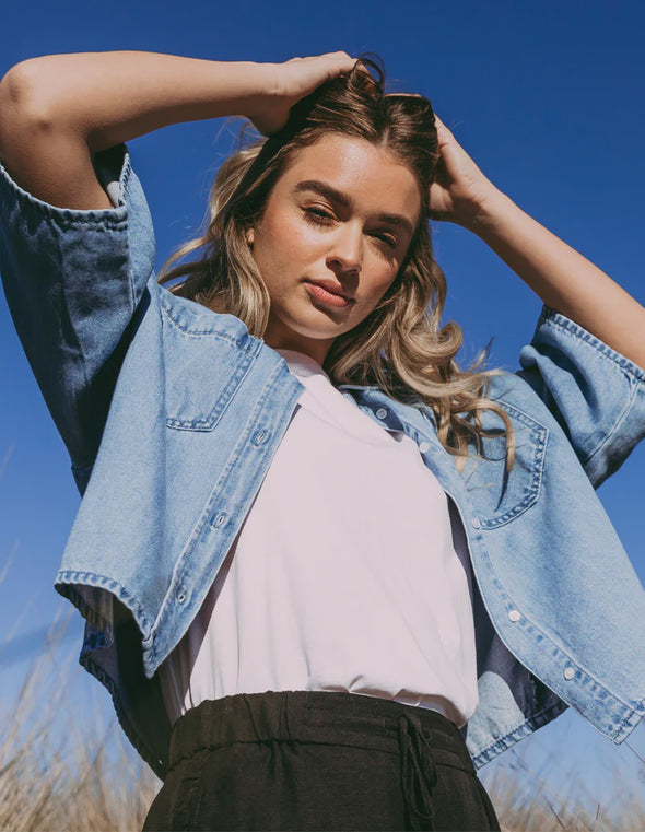 Get ready to elevate your denim game with the Foxwood Hutton Denim Shirt. This versatile shirt features a relaxed, boxy fit and elbow-length sleeves for a stylish update on the classic denim look. Pair it with trousers for a chic outfit, or throw it over a dress for effortless style. Your wardrobe's new MVP has arrived!