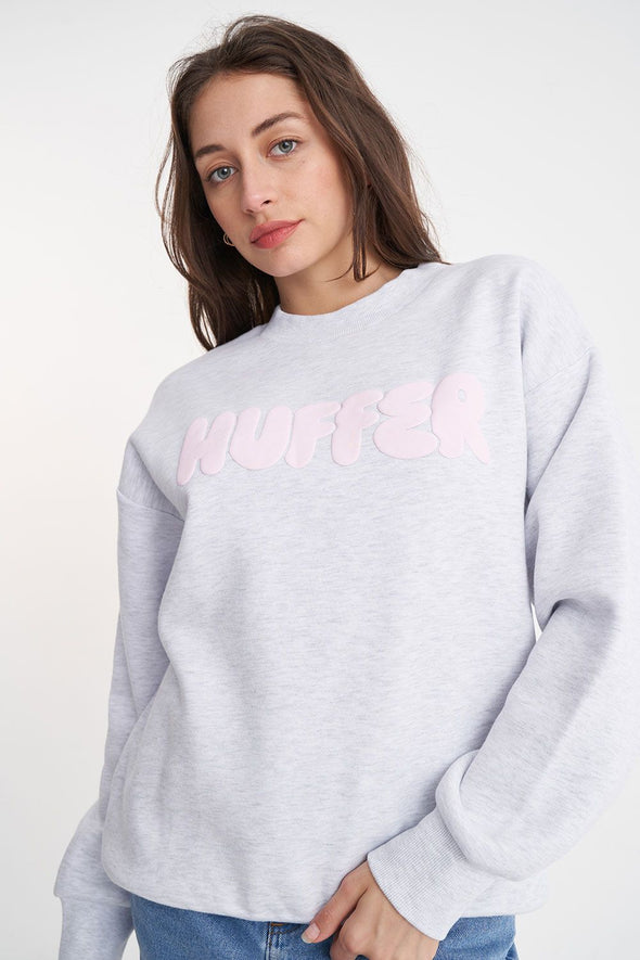 Stay cozy and stylish in the Huffer Crewneck! With a playful twist on the classic crewneck, this sweater features a bold pale pink "Huffer" graphic across the chest in bubble letters. Perfect for any occasion.&nbsp;