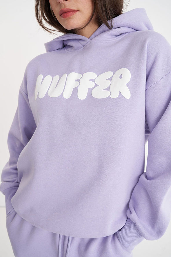 Get ready to rock a cool and playful vibe with our Huffer Hoodie! Featuring bold huffer branding in fun bubble writing, this purple hoodie is the perfect addition to any quirky outfit. Stay cool and stay stylish with this must-have piece.