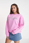 A classic Huffer crewneck in an icon shade of pink; Bon Bon. Rope detail spelling out the word Huffer.