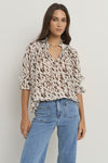 Oversized fit with flowing movement

Ruffle collar and elastic cuffs for added shape

Subtle v-neckline with easy pull-on design

Chocolate-toned animal print for a bold yet elevated look

Crafted from a breathable Tencel, linen, and nylon blend