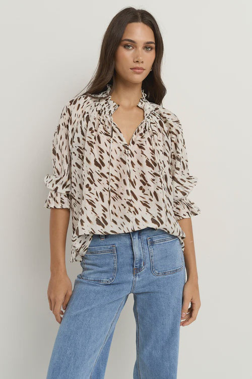 Oversized fit with flowing movement

Ruffle collar and elastic cuffs for added shape

Subtle v-neckline with easy pull-on design

Chocolate-toned animal print for a bold yet elevated look

Crafted from a breathable Tencel, linen, and nylon blend